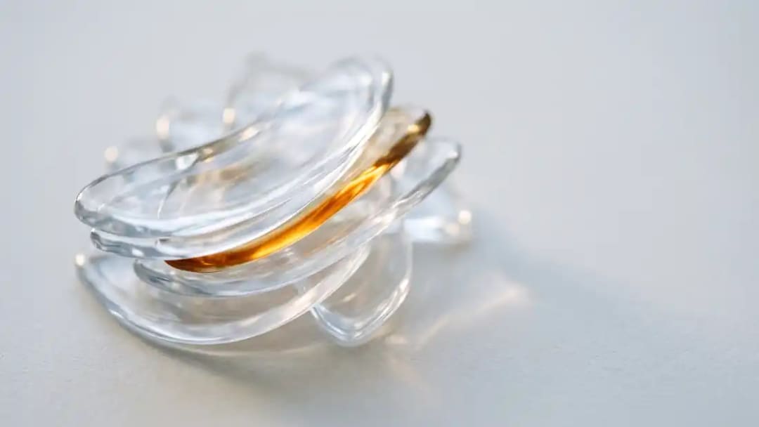 A stack of clear plastic aligner trays